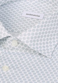 Weißes Hemd mit hellblauem geometrischem Muster, weichem Stoff, Knopfdetails und einem Etikett mit der Aufschrift "seidensticker".