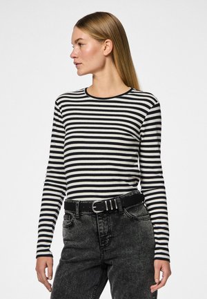 Haut à rayures noires et blanches à manches longues avec un col rond. Associe à un jean noir taille haute et une ceinture noire avec une boucle en argent.