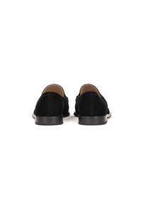 Zapatos de ante negro con un tacón bajo y textura suave; presentan un diseño sencillo sin herrajes ni acentos prominentes.