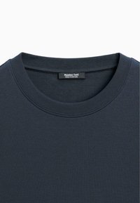 Sweat-shirt bleu marine foncé à col rond côtelé avec une étiquette « Massimo Dutti Made in Portugal » à l’intérieur de l’encolure.