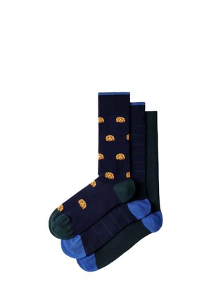 Tres pares de calcetines de colores oscuros, uno azul marino con pequeñas caras de perros naranjas, uno oscuro a rayas y uno verde oscuro sólido con talones y dedos azules.