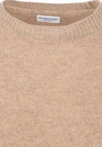 Beige gebreide trui met een ribbelkraag, lichte textuur en subtiel patroon. Label zichtbaar: "McGREGOR New York."
