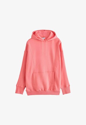 Hoodie rose corail en tissu doux, avec une poche avant, un capuchon à cordon de serrage, et de larges manches avec des poignets côtelés.