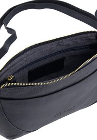 Torba crossbody w ciemnoniebieskiej skórze, z zamkiem błyskawicznym w kolorze złotym, fakturowaną powierzchnią oraz wewnętrznymi kieszeniami na akcesoria. Widoczne logo marki.