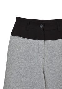 Pantalon gris avec une taille noire, texture lisse, doté d'une fermeture à bouton et de poches. Le design est simple et moderne.