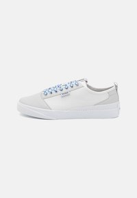 Baskets blanches basses avec des lacets bleus et blancs, des panneaux latéraux texturés et une étiquette logo "HUGO" sur le côté, sur fond clair.