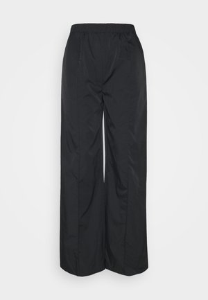 Zwarte broek met wijde pijpen, gemaakt van een glad, lichtgewicht materiaal. Voorzien van een elastische tailleband en twee zijnaden voor extra stijl.