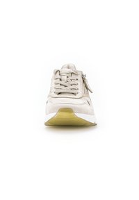 Beige sneaker met een bovenkant van suede, gestructureerde veters, een zijrits en een witte tussenzool. Heeft een rubberen gele buitenzool voor grip.