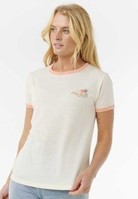 T-shirt en coton couleur crème avec des manches courtes et des accents en corail. Présente un graphisme subtil de palmiers et d'un coucher de soleil sur le devant.