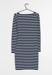 Marinblå och vit randig långärmad klänning, figurnära design, båtutskärning, mjukt tyg, hängande på en svart krok mot en enfärgad bakgrund.