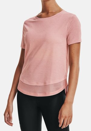 Vrouw draagt een lichtroze shirt met korte mouwen en een mesh zoomdetail, gecombineerd met zwarte legging, weergegeven van schouders tot heupen.