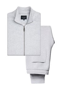Szary sweatshirt zapinany na zamek z wysokim kołnierzem, z metalowym zamkiem błyskawicznym i bocznymi kieszeniami. Towarzyszą mu dopasowane szare dresy z mankietami na nogawkach.