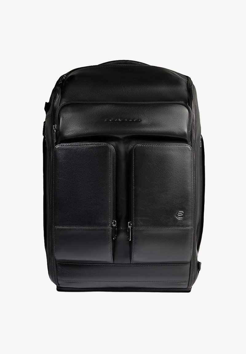 Mochila de cuero negro con textura suave, que cuenta con dos bolsillos frontales con cremallera y un detalle de logotipo en la parte inferior derecha.