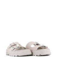 Sandales gris clair avec une finition en suede, dotées de deux sangles réglables et d'une semelle en caoutchouc solide avec des détails de traction.