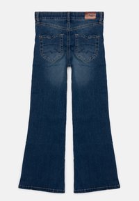 Džínové zvonové kalhoty v tmavě modré barvě s hladkou texturou, s dvěma dekorativními zadními kapsami a koženou etiketou na pásku.