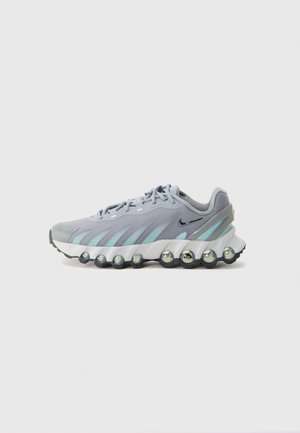 Baskets de sport avec une tige en mesh gris et bleu clair, dotées d'une semelle texturée avec des coussins d'air et d'un design à lacets.