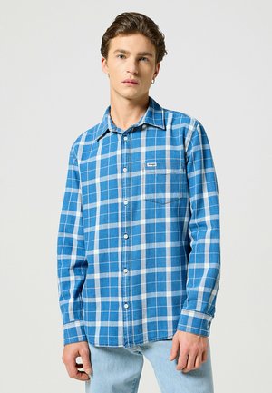Camisa de franela a cuadros azul y blanca con cuello abotonado, bolsillo en el pecho y corte regular, fabricada en suave tela de algodón.