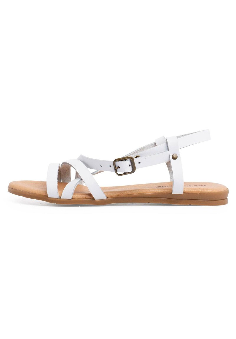 Sandali bianchi in pelle con cinturini incrociati, fibbia regolabile alla caviglia e suola piatta marrone. Texture liscia e design minimalista.