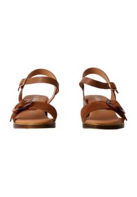 Braune Wildledersandalen mit zwei Zehenriemen und einem Knöchelriemen, ausgestattet mit einer dekorativen dunkelbraunen Schnalle, flacher Sohle und minimalistischem Design.