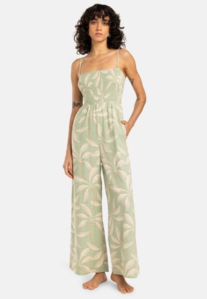 Lichtgroene jumpsuit met een gesmockte bodice en dunne bandjes. Kenmerkend is het palmbladpatroon en het losse, wijde ontwerp met zakken.