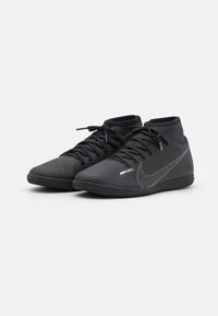 Czarne piłkarskie buty Nike Mercurial charakteryzują się teksturowaną cholewką z poziomymi prążkami, wysokim krojem oraz wyraźnym logo swoosh.