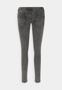 Jeans ajustados en denim gris, con una cintura de altura media, diseño de cinco bolsillos y un leve desgaste en la tela para añadir textura.