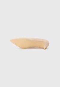 Zapato de tacón alto de ante beige con puntera afilada y tacón delgado, que presenta una parte superior de textura suave y una suela de goma lisa.