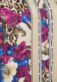 Blomster- og leopardprint stof med gyldne ornamentale kæder, blå og lilla blomster, beige striber og "Just Cavalli" tekst på knapperne.