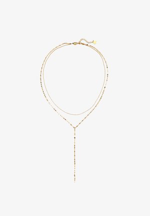 Złota naszyjnik warstwowy z delikatnymi łańcuszkami, z projektem lariat i małymi koralikami przywiązanymi do pasm, o błyszczącym wykończeniu i regulowanym zapięciu.