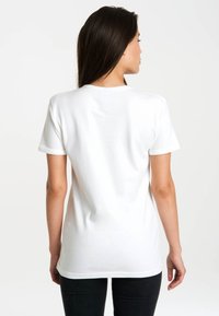 White cotton t-shirt with short sleeves, round neckline, and a smooth texture. Back view shows a slightly curved hemline and no graphic design.