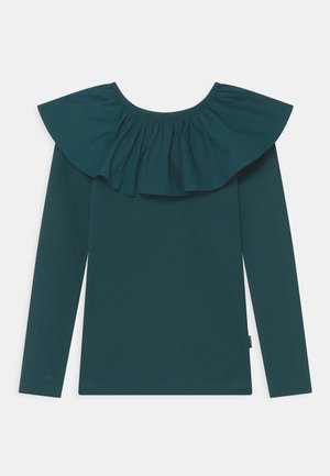 Camisa de manga larga verde oscuro con cuello ancho y volante que rodea el escote, con una textura de tela suave.