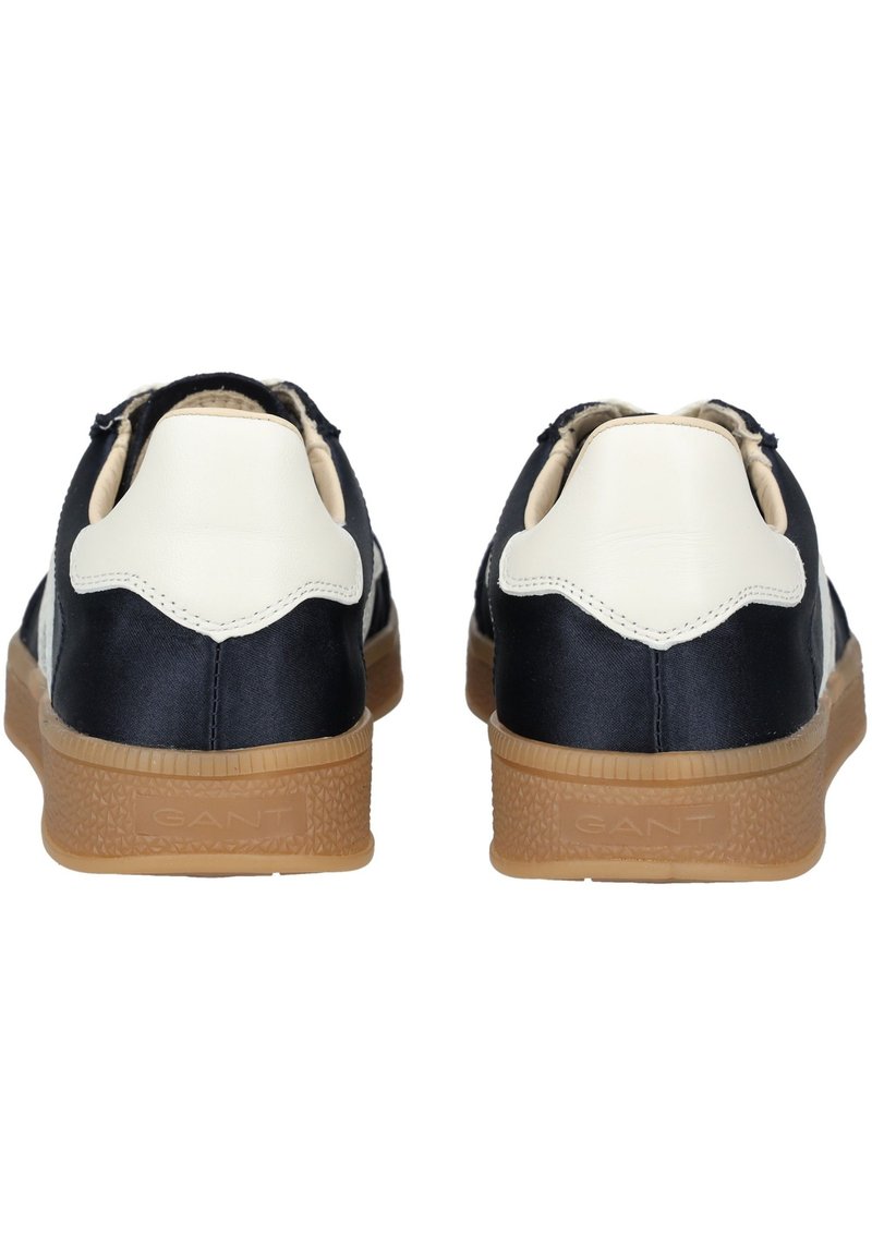 Granatowe i kremowe buty sportowe z gładką skórzaną cholewą i teksturowaną gumową podeszwą, wyróżniające się kontrastowym obcasem oraz logiem marki po boku.