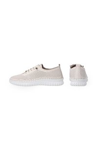 Helle beige, perforierte Sneakers mit einer weißen, strukturierten Sohle und passenden Schnürsenkeln. Rundliche Form, minimalistisches Design und keine sichtbaren Logos.