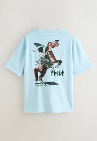 Tricou din bumbac albastru deschis, cu un print grafic al unui cowboy călărind un cal în picioare, având ilustrații cu cactuși sub scena respectivă.