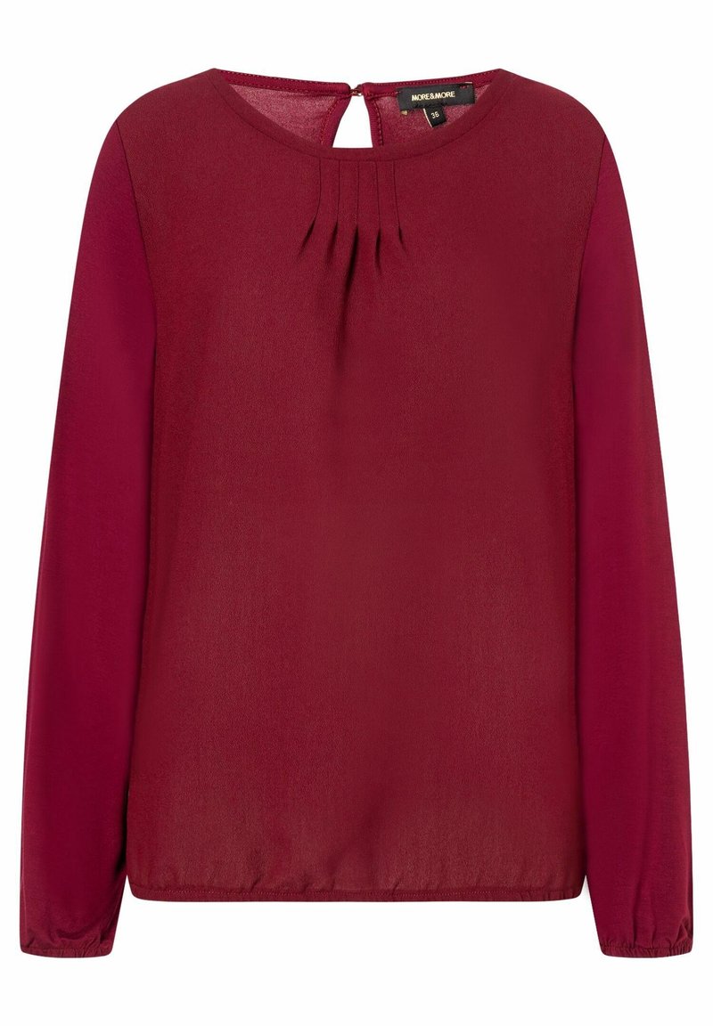 Blusa bordeaux a maniche lunghe con scollo rotondo, pieghe davanti, dettaglio a chiave sul retro e polsini elastici. Tessuto dalla finitura liscia.