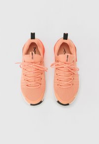 Scarpe da ginnastica color pesca chiaro con tomaia in mesh strutturato, linguetta nera a contrasto sul tallone e suola bianca. I lacci sono dello stesso colore della scarpa.