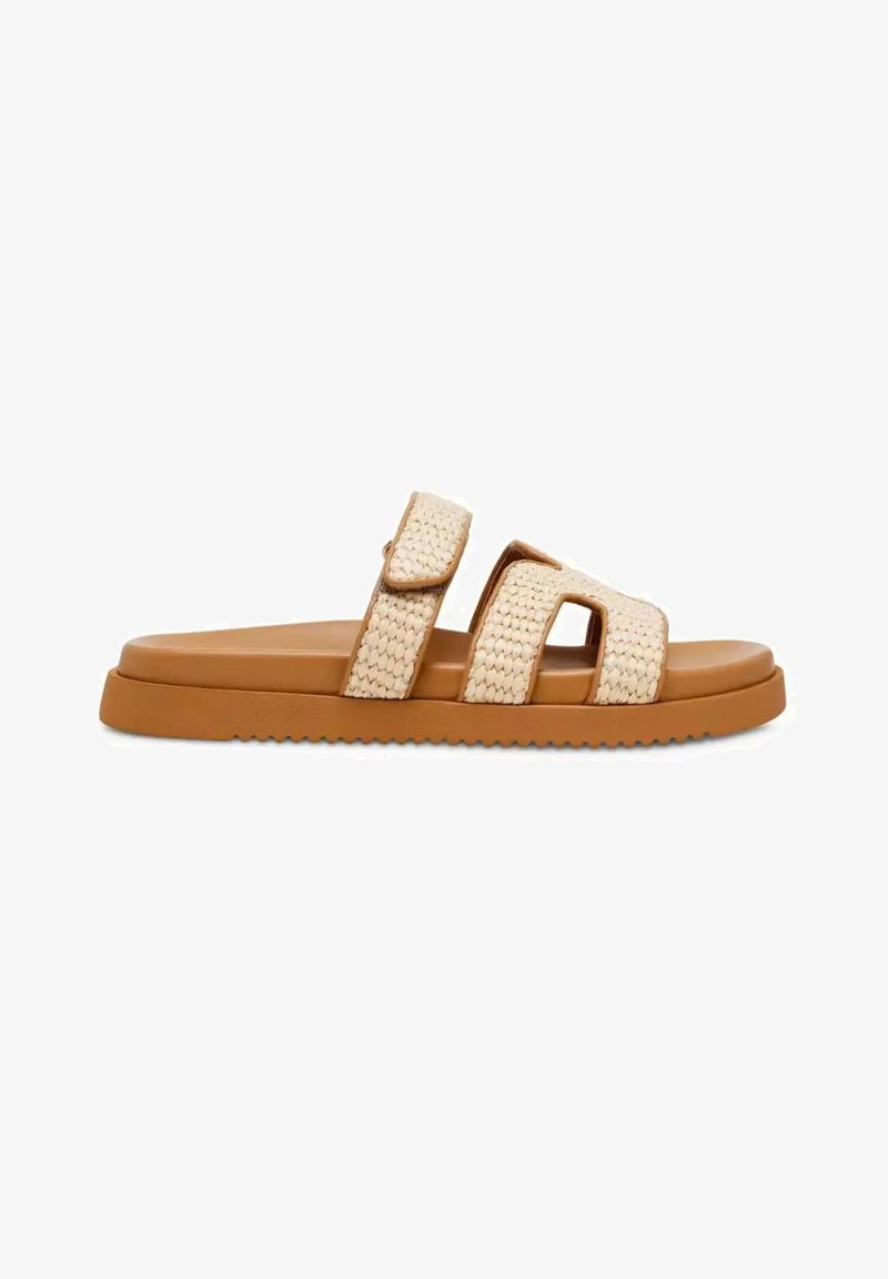 Sandale à enfiler avec une semelle beige et deux larges brides tissées beige, dont une avec une fermeture Velcro pour un ajustement ajustable.