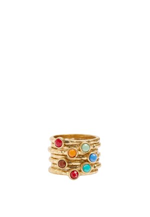 Stos siedmiu teksturowanych złotych pierścieni z okrągłymi kamieniami szlachetnymi w kolorach czerwonym, pomarańczowym, brązowym, jasnym zielonym, niebieskim, turkusowym i czerwonym.