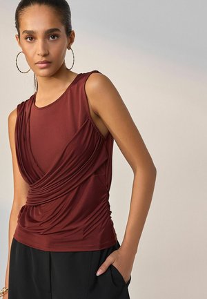 Burgundy sleeveless top with gathered fabric, featuring a draped design at the front. Comes with a smooth texture and a fitted silhouette.