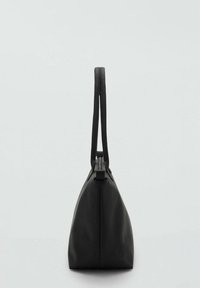 En elegant svart väska med en strukturerad design och två långa handtag, sedd från sidan mot en ljus bakgrund.