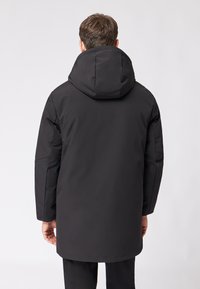 Czarna, ocieplana parka z dużym kapturem, o prostym kroju i teksturowanej tkaninie. Bez widocznych elementów metalowych ani wzorów.