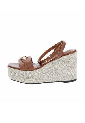 Sandalia cuña de cuero marrón con correa en el tobillo y hebilla dorada, con una suela plataforma gruesa de tejido beige.