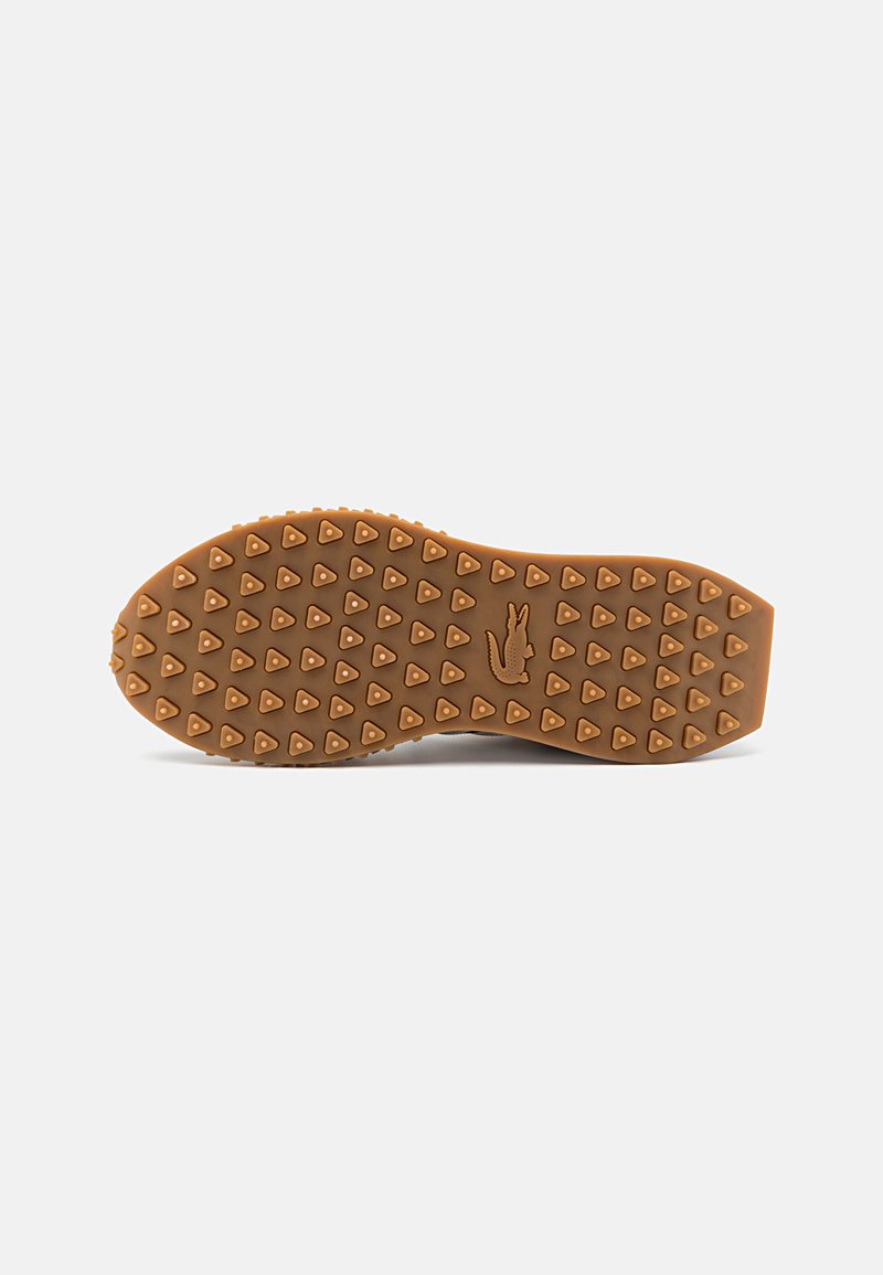 Semelle de chaussure en caoutchouc avec un design texturé brun présentant des clous en forme de triangle et une empreinte de logo subtile. Bout et bords de talon arrondis et lisses.