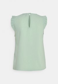Light green short-sleeve blouse with a keyhole back and ruffled shoulder accents; smooth texture, casual design.