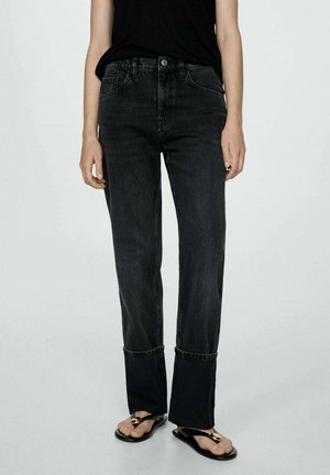 Black denim jeans with a straight leg design, featuring subtle whiskering, a high waist, and cuffed hems. Worn with flat sandals.