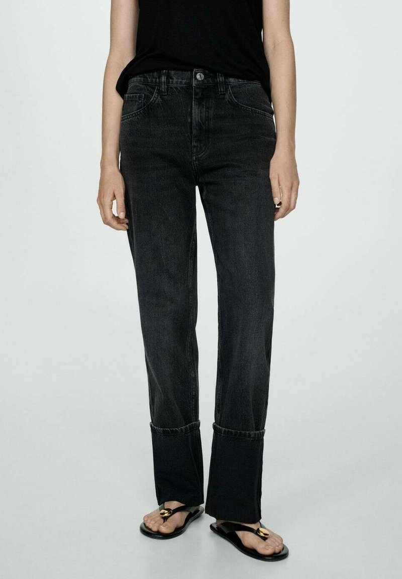 Black denim jeans with a straight leg design, featuring subtle whiskering, a high waist, and cuffed hems. Worn with flat sandals.
