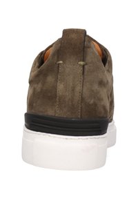 Zapatillas de ante en verde olivo con una suela de goma blanca. La parte trasera cuenta con un acento texturizado en negro y un lazo para facilitar el calzado.