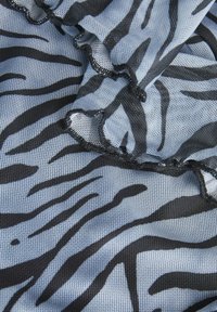 Tessuto a rete nero e blu con motivo a strisce di zebra, caratterizzato da bordi arricciati e una superficie testurizzata.