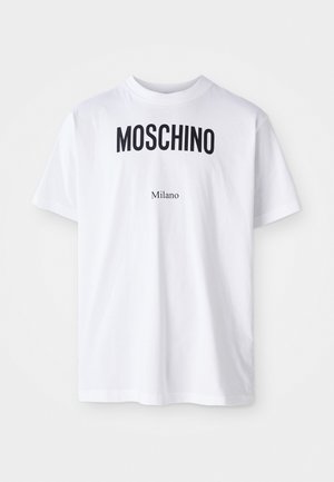 Biała bawełniana koszulka z krótkim rękawem, na której widnieje wyraźny czarny napis "MOSCHINO" nad mniejszym napisem "Milano". Klasyczny okrągły dekolt.