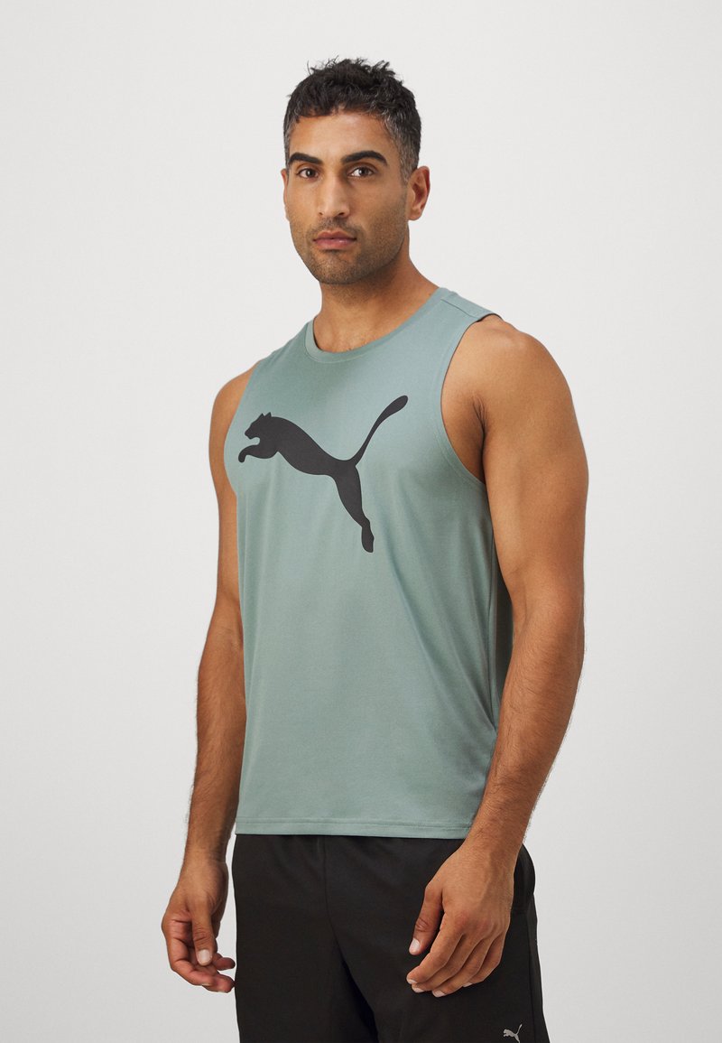 Zöld ujjatlan sportos tank top, amelyen egy nagy fekete Puma logó található a mellkasnál; sima anyag, lazább fazon.